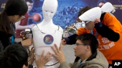 在北京舉行的世界機器人大會上，中國學生展示機器人。