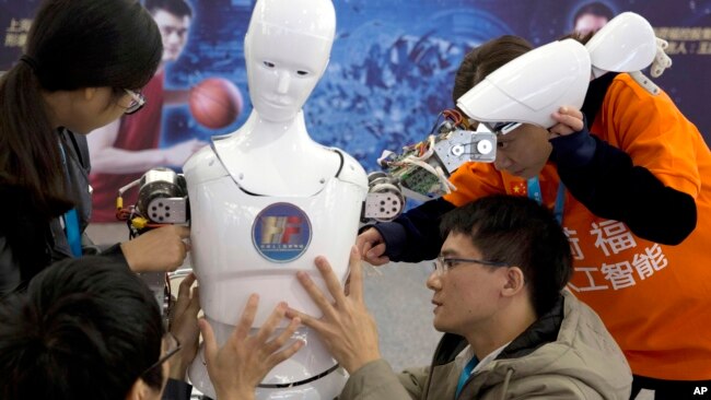在北京举行的世界机器人大会上，中国学生展示机器人。