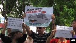 Người biểu tình tại Hà Nội cầm biểu ngữ lên án hành động xâm phạm chủ quyền của Trung Quốc ở Biển Đông, ngày 2/6/2013.