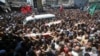 巴勒斯坦人在葬礼中抬着死于空袭的三名哈马斯高级指挥官的尸体
