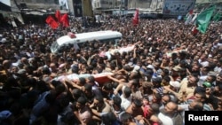 Palestinians carry the bodies of three senior Hamas commanders, who were killed in an Israeli air strike, during their funeral in Rafah in the southern Gaza Strip, Aug. 21, 2014. 