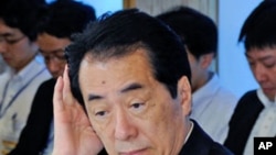 Japanese Prime Minister Naoto Kan gestures upon his arrival for a cabinet meeting on environment and energy at Kan's official residence in Tokyo, June 22, 2011