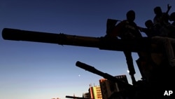 Libyan boys sit on the cannon of a destroyed army tank in Misrata, Libya, June 13, 2011