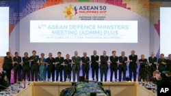 ASEAN defense chiefs link arms during a brief photo session at the start of the ASEAN Defense Ministers' Meeting and its Dialogue Partners Tuesday, Oct. 24, 2017, in Clark, Pampanga province, north of Manila, Philippines.