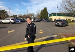 Eugene police officers stand outside the Cascade Middle School in Eugene, Oregon, Jan. 11, 2019, following an officer-involved shooting.