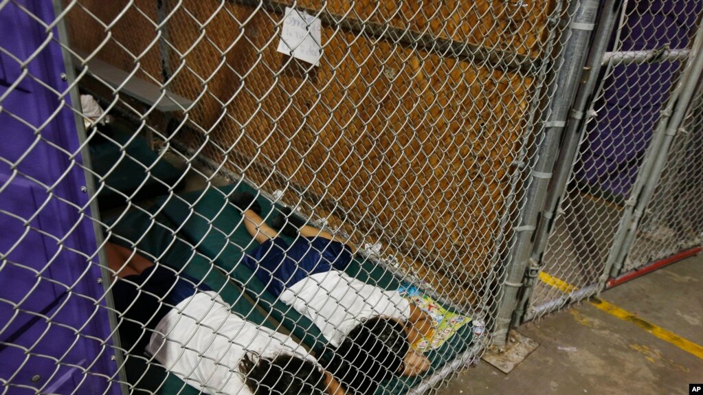 Tư liệu - Trong bức hình chụp vào tháng năm 2014, hai người nữ nằm ngủ trong buồng giam trong khi trẻ em được tách riêng theo nhóm tuổi và giới tính, tại một trung tâm giam giữ di trú ở Nogales, bang Arizona.