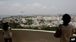 FILE - Visitors look out over U.S. Marine Corps Air Station Futenma in Ginowan on Okinawa, Japan, May 3, 2010. The Japanese and U.S. governments want the Futenma Air Base located in the middle of a crowded city moved to a sparsely populated area for safety reasons.