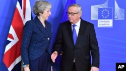 European Commission President Jean-Claude Juncker, right, prepares to shake hands with British Prime Minister Theresa May, left, before their meeting at the European Commission headquarters in Brussels, Belgium, Feb. 7, 2019. 