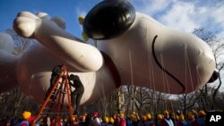 Workers prepare the giant Snoopy balloon before the 87th Annual Macy's Thanksgiving Day Parade, New York, Nov. 28, 2013. 