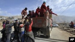 People chase a truck as Tibetan Buddhist monks distribute relieves goods amid the earthquake devastation in Jiegu, Yushu county, in China's northwestern province of Qinghai on April 19, 2010. AFP PHOTO/ LIU Jin