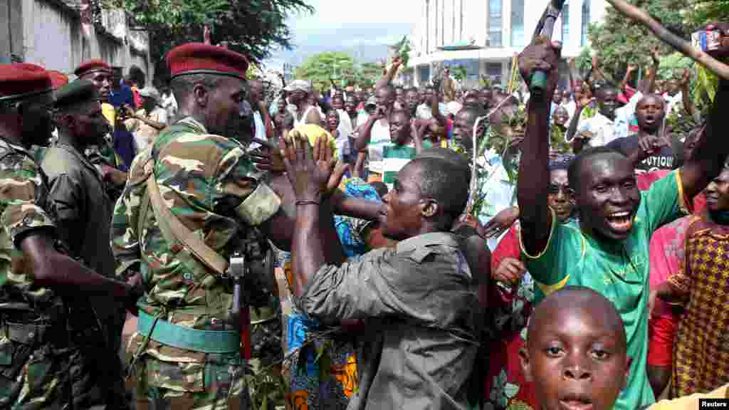People greet soldiers as they celebrate in Bujumbura, Burundi May 13, 2015. Crowds poured onto the streets of Burundi's capital on Wednesday to celebrate after a general said he was dismissing President Pierre Nkurunziza for violating the constitution by