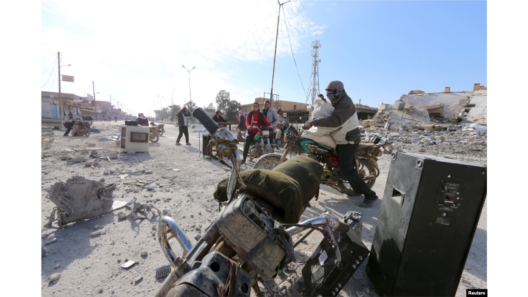 Men loot goods in al-Shadadi town, Hasaka countryside, Syria, Feb. 26, 2016.