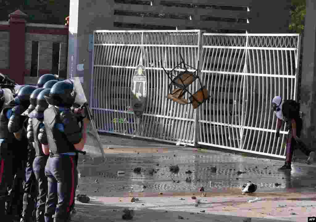 A masked student from the National Autonomous University of Honduras (UNAH), clashes with riot police during a protest against the reelection of President Juan Orlando Hernandez in Tegucigalpa, Honduras, Oct. 18, 2017.