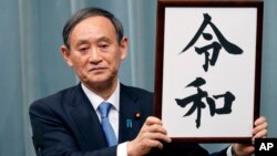 Japan’s Chief Cabinet Secretary Yoshihide Suga unveils the name of new era “Reiwa” at the prime minister’s office in Tokyo, Monday, April 1, 2019. 