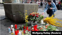 Homem coloca uma vela no local do incidente, 8 de Abril, 2018.REUTERS/Wolfgang Rattay 