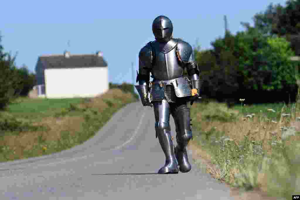 French artist and performer Abraham Poincheval wears a plate armor as he walks in Carnoet, western France, July 9, 2018.