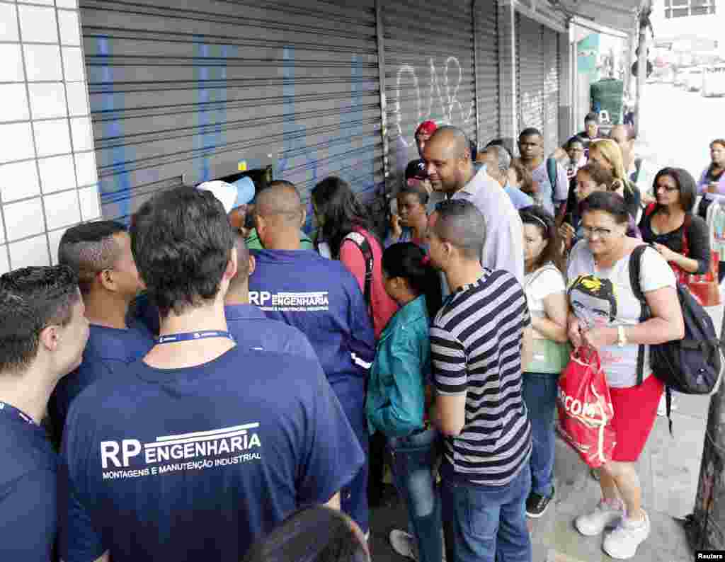 Shoppers crowd outside a store before it opens on Black Friday in Sao Paulo, Nov. 28, 2014.