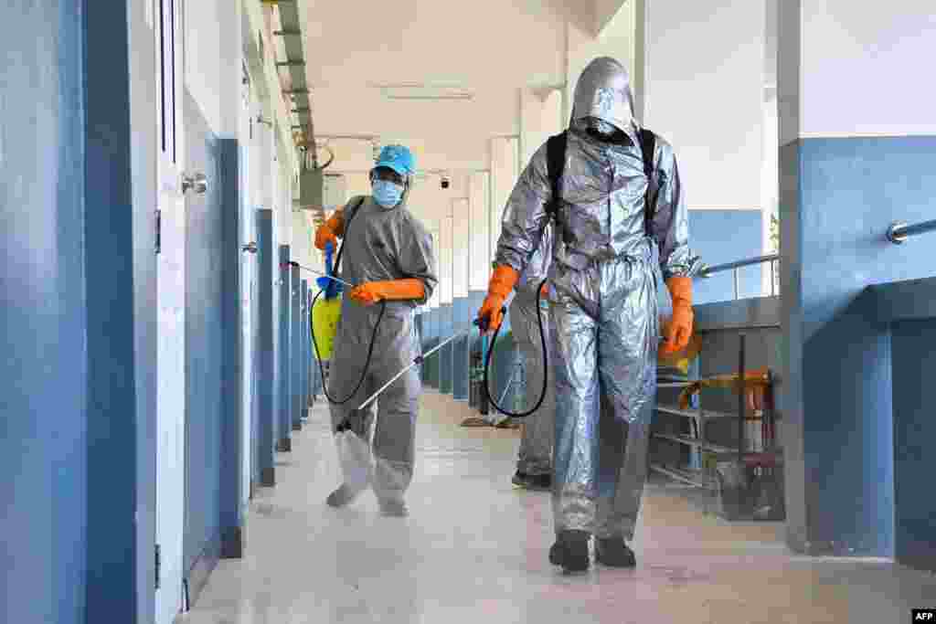 Military personnel in protective suits disinfect a school in Ubon Ratchatani province to prevent the spread of COVID-19, in this handout photo from the Royal Thai Army. 