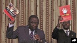 Zimbabwe Prime Minister and Movement For Democratic Change (MDC) leader Morgan Tsvangirai (L) and National Organising Secretary Nelson Chamisa present a booklet at the launch of Conditions for a Sustainable Election in Zimbabwe (COSEZ) in Harare, March 8