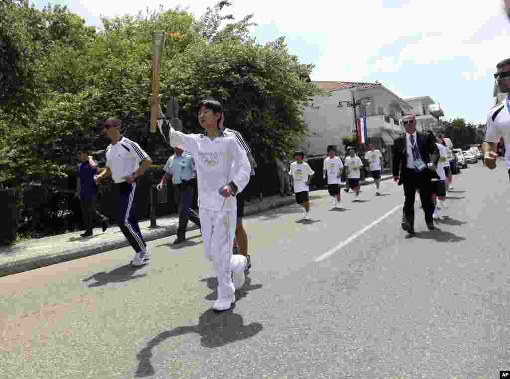 Torchbearer Yuya Umehara runs with the Olympic flame during the Olympic torch relay.