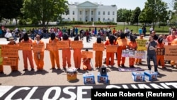 Activists wearing orange jumpsuits mark the 100th day of prisoners' hunger strike at Guantanamo Bay during a protest in front of the White House in Washington May 17, 2013. 