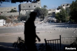 FILE - A member of Palestinian Hamas security forces walks past a Hamas site that was hit in an Israeli airstrike, in Al-Mughraqa on the outskirts of Gaza City, Aug. 9, 2018.