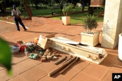 A police officer guards exhibits recovered during fuel protests and on display outside the magistrates courts in Harare, Jan. 18, 2019. Among the items was a coffin that protesters used to signify the death of Zimbabwean President Emmerson Mnangagwa's administration.