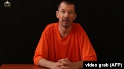 An image grab taken from a video released by the Islamic State (IS) group through Al-Furqan Media via YouTube allegedly shows British freelance photojournalist, John Cantlie, at an undisclosed location in which he says he is being held captive, Sept. 18, 