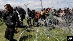 Migranti pokušavaju da prođu kroz ogradu u Idomeni na granici Grčke i Makedonije, 10. april 2016. 