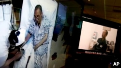 Video clips show China's jailed Nobel Peace laureate Liu Xiaobo lying on a bed receiving medical treatment at a hospital, left, and Liu saying wardens take good care of him, on a computer screens in Beijing, June 29, 2017.