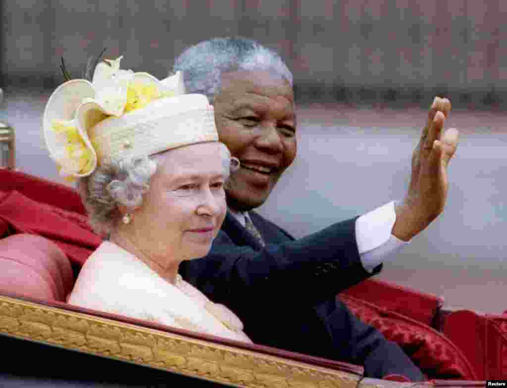 Nelson Mandela and Britain's Queen Elizabeth II ride in a carriage outside Buckingham Palace on the first day of a state visit to Britain, July 9, 1996. 