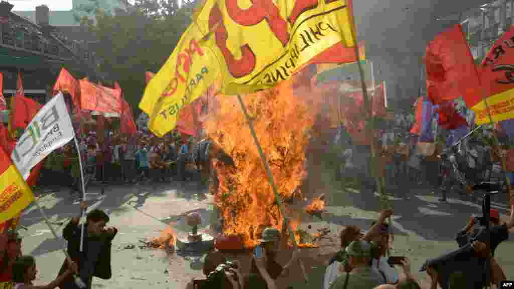 Protesters set fire to an effigy of Philippine President Benigno Aquino during a May Day rally near the presidential palace in Manila.