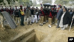 Pakistani police carry the coffin of Punjab Gov. Salman Taseer, shortly before burial in a cemetary in Lahore, Pakistan, Jan. 5, 2011.