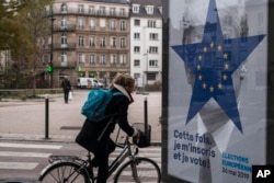 A cyclist rides past of campaign poster by the Strasbourg municipality for the upcoming European elections in Strasbourg, eastern France, Nov. 22, 2018.