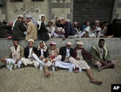 Yemeni anti-government protesters rest sitting on a sidewalk chewing Qat during clashes between the factions in Sana'a, March 13, 2011.