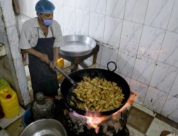 Seorang juru masak tengah menggoreng sambusa di sebuah restoran di Sanaa, Yaman, pada bulan suci Ramadan, 15 April 2021. (REUTERS / Khaled Abdullah)