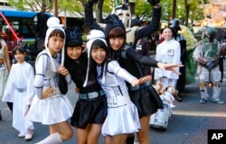 FILE - "Star Wars" fans dressed in costumes of "Star Wars" characters pose for a photo during a Halloween parade in Kawasaki, near Tokyo, Oct. 25, 2015.