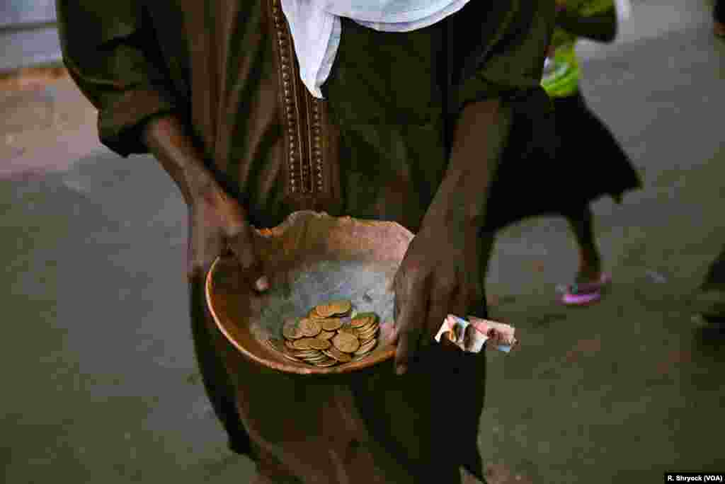 A man takes donations to help with the costs of making the Ndogou meal, which they then share with anyone who passes by as the sun sets and it’s time to break the Ramadan fast each night in Dakar, Senegal.