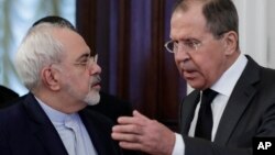 FILE - Russian Foreign Minister Sergei Lavrov, right, speaks to Iranian Foreign Minister Mohammad Javad Zarif as they enter a hall for the talks in Moscow, Russia, Dec. 20, 2016. In the past few years an alliance — at times shaky — between Moscow and Tehran has developed. 