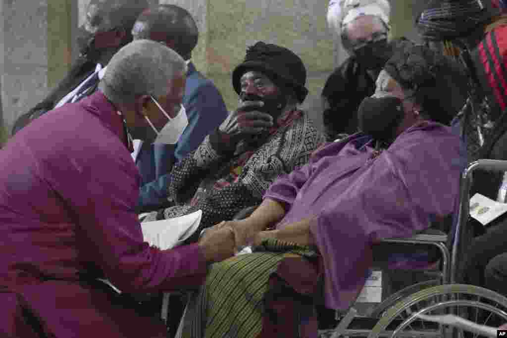 Anglican Archbishop of Cape Town, Thabo Makgoba, left, greets widow Leah Tutu at the funeral of Anglican Archbishop Emeritus Desmond Tutu in St. George&#39;s Cathedral in Cape Town, South Africa, Jan. 1, 2022.