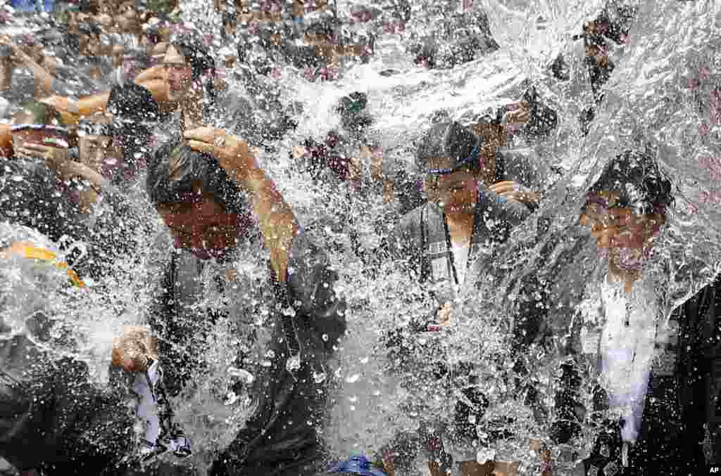 Festival-goers are splashed with water during a summer festival at Tomioka Hachimangu Shrine in downtown Tokyo, Japan.