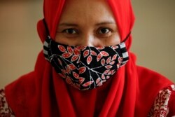 Seorang perempuan mengenakan masker kain dari batik tradisional Indonesia di sebuah bengkel di Jakarta, 1 Juli 2020. (Foto: REUTERS/Willy Kurniawan)