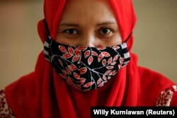 Una mujer usa una máscara de tela hecha de batik indonesio tradicional en un taller en Yakarta, el 1 de julio de 2020. (Foto: REUTERS/Willy Kurniawan)