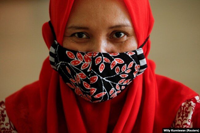 Seorang perempuan mengenakan masker batik tradisional Indonesia di sebuah bengkel di Jakarta, 1 Juli 2020. (Foto: REUTERS/Willy Kurniawan)