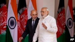 Indian Prime Minister Narendra Modi, foreground, and Afghan President Mohammad Ashraf Ghani walk for a meeting in New Delhi, India, Tuesday, April 28, 2015.