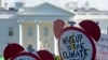 FILE- Protesters gather outside the White House in Washington to protest President Donald Trump's decision to withdraw the Unites States from the Paris climate change accord, June 1, 2017. 