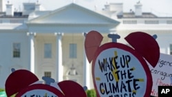 FILE- Protesters gather outside the White House in Washington to protest President Donald Trump's decision to withdraw the Unites States from the Paris climate change accord, June 1, 2017. 