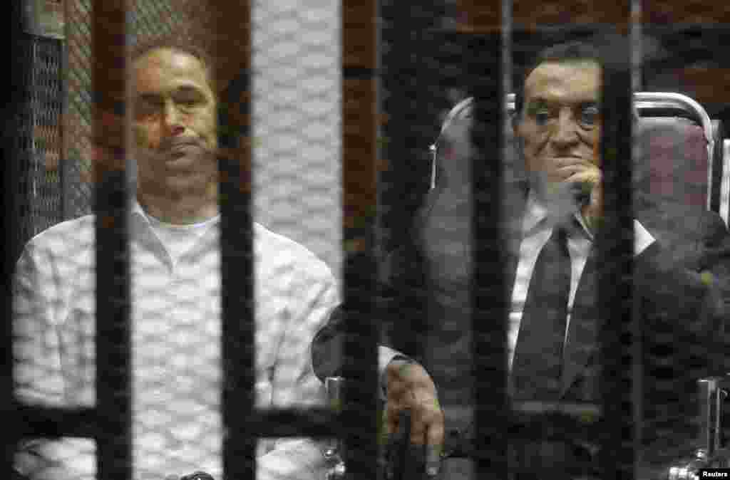 Egypt&#39;s ousted president Hosni Mubarak sits next to his son Gamal (left) inside a dock at the police academy on the outskirts of Cairo, May 21, 2014.