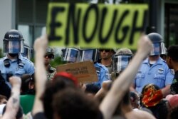 Protesters rally in Philadelphia as Philadelphia police officers and Pennsylvania National Guard soldiers look on, June 1, 2020.