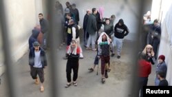 FILE - Prisoners from Iraq and Syria, suspected of being part of the Islamic State, spend time in a prison's outside grounds in Hasaka, Syria, Jan. 11, 2020. 